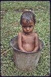 Young child bathes in a bucket of water