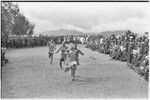 Government-sponsored festival in Tabibuga: adolescent girls run a race, watched by crowd