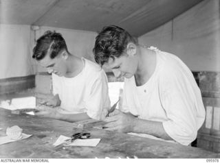 CAPE WOM, WEWAK AREA, NEW GUINEA. 1945-09-01. CORPORAL R.L. TERRY (1) AND CORPORAL MCNAUGHTON (2), MEMBERS OF 2/4 DENTAL UNIT ATTACHED HEADQUARTERS 6 DIVISION PREPARING DENTURES FOR INSERTION