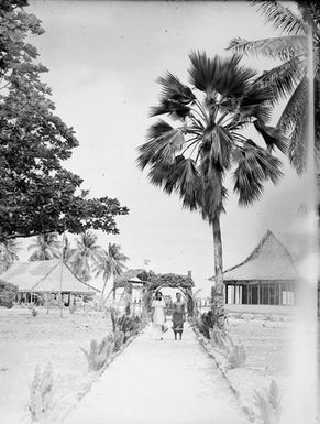 [Portrait of a Polynesian couple standing on a pathway]