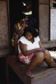 French Polynesia, women sitting on steps of home on Tahiti Island