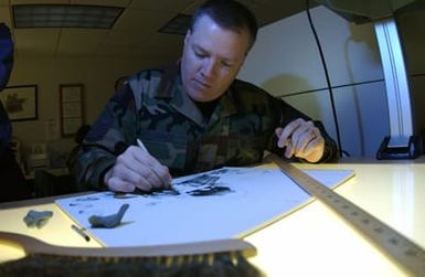 US Air Force (USAF) MASTER Sergeant (MSGT) Cody Vance, Graphic Artist, 15th Communications Squadron (CS), Hickam Air Force Base (AFB) Hawaii (HI) works on one of the many illustrations he creates for the Air Force
