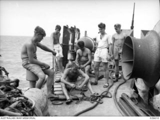 PORT MORESBY, PAPUA. 1942-09. SAILORS AT WORK ON BOARD H.M.A.S. BENDIGO ON ARRIVAL AT PORT MORESBY AFTER CONVOYING TROOPS AND SUPPLIES FROM AUSTRALIA