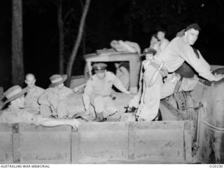 MILNE BAY, PAPUA. 1943-11-15. TIRED OUT AFTER A LONG NIGHT FLIGHT, THESE BEAUFORT BOMBER CREWS OF NO. 6 SQUADRON RAAF CLIMB ONTO A TRUCK WHICH WILL TAKE THEM BACK TO CAMP AFTER TAKING PART IN THE ..
