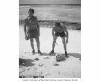 Scientists Allyn H. Seymour and Richard H. Osborn preparing to remove clam from shell probably on Namu Island, 1947