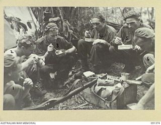 BOUGAINVILLE. 1945-04-30. A PATROL FROM D COMPANY, 9 INFANTRY BATTALION, ENJOYING A HOT MEAL AFTER RETURNING FROM A PATROL ALONG THE HONGORAI RIVER. THE UNIT IS IN PROCESS OF BEING RELIEVED BY ..