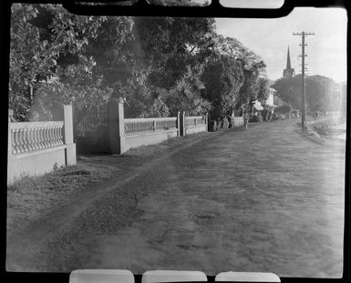 Road scene in Papeete, Tahiti, showing road close to sea bank and a few people on their bicycles