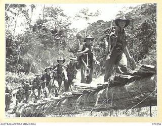 FARIA VALLEY, NEW GUINEA, 1944-02-09. MEMBERS OF THE 2/10TH INFANTRY BATTALION CROSSING THE FARIA RIVER. THEY ARE FOLLOWING THE RIVER TO NEW POSITIONS IN THE RAMU VALLEY