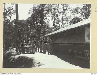 TOROKINA, BOUGAINVILLE. 1945-04-19. A GROUP OF PATIENTS WITH THE RED CROSS SOCIETY REPRESENTATIVE OUTSIDE THE SOCIETY'S OFFICE AT 2/3 CONVALESCENT DEPOT. IDENTIFIED PERSONNEL ARE:- SAPPER B. ..