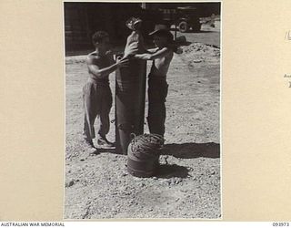 PALMALMAL PLANTATION, JACQUINOT BAY, NEW BRITAIN, 1945-07-13. PERSONNEL OF HEADQUARTERS 31 SUPPLY DEPOT COMPANY PLACING AUSTRALIAN COMFORTS FUND BAG OF COMFORTS INTO "STORPEDO" WITH OTHER ARMY ..