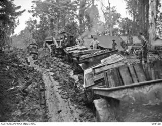 SOUTH BOUGAINVILLE. 1945-07-29. A TRACTOR TRAIN OF 3 SUPPLY DEPOT PLATOON, CARRYING FRESH MEAT, BUTTER AND VEGETABLES, MAKING ITS WAY ALONG THE MUDDY BUIN ROAD, EAST OF THE OGORATA RIVER. FRESH ..