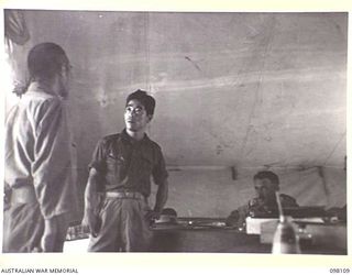 CAPE WOM, NEW GUINEA. 1945-10-19. CORPORAL YAMAMOTO, OF THE JAPANESE ARMY, BEING QUESTIONED AT HEADQUARTERS 6 DIVISION, BY THE WEWAK WAR CRIMES COMMISSION, WHICH IS COLLECTING SUMMARIES OF EVIDENCE ..