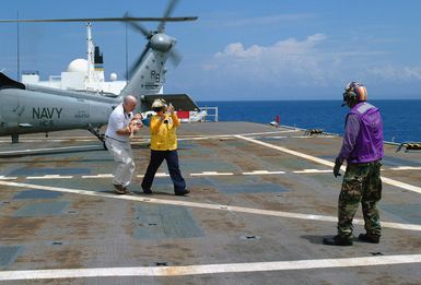 Dr. Dana Braner (left), Project HOPE (a civilian organization of medical volunteers), assisted by US Navy (USN) Information Systems Technician Second Class (IT2) Sheronda Allen, carry an Indonesian child in respiratory distress from a USN MH-60S Seahawk helicopter, Helicopter Combat Support Squadron 5 (HC-5), Andersen Air Force Base (AFB), Guam, onboard the Military Sealift Command (MSC) hospital ship USNS MERCY (T-AH 19). The child was medically evacuated from the island of Nias, Indonesia to the ship, where MERCY's medical personnel are conducting humanitarian assistance operations in the wake of the devastating earthquake that struck the island on March 28, 2005