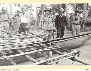 WANIGELA, NEW GUINEA. 1942-10. GENERAL SIR THOMAS BLAMEY GBE KCB CMG DSO ED, COMMANDING ALLIED LAND FORCES, SOUTH WEST PACIFIC AREA, INSPECTING A NATIVE CANOE WHICH WAS SUGGESTED AS A POSSIBLE ..