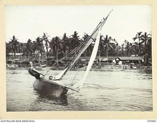 JACQUINOT BAY, NEW BRITAIN. 1945-03-11. AUSTRALILAN ARMY PERSONNEL SAILING THEIR HOME MADE SAILING BOAT AROUND THE BAY WHILE WATCHING THE EVENTS DURING THE AQUATIC CARNIVAL OF THE NEW BRITAIN YACHT ..