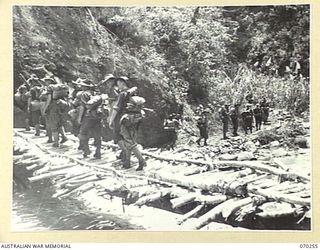 FARIA VALLEY, NEW GUINEA, 1944-02-09. MEMBERS OF THE 2/10TH INFANTRY BATTALION CROSSING THE FARIA RIVER. THEY ARE FOLLOWING THE RIVER TO NEW POSITIONS IN THE RAMU VALLEY