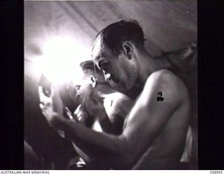 KONEBOBU (KANEDABU), NEW GUINEA. 1943-10-27. MEMBERS OF THE 7TH AUSTRALIAN DIVISION CONCERT PARTY MAKING UP IN THEIR TENT BEFORE THE SHOW. THEY ARE: SX1552 SERGEANT A. J. CLARK (1); NX68675 PRIVATE ..