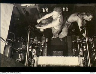 Port Moresby, New Guinea. 1944-06-15. An elevated view of Lieutenant E. S. H. Morrison, Chief Engineer (left), and Lance Corporal E. O'Donnell, both of 12 Water Transport Operating Company, Royal ..
