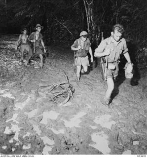 1942-11-23. New Guinea. Australians plod along "The Track" on the way to Buna