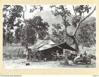 PORT MORESBY, PAPUA. 1942-07. A NEW GUINEA WORKSHOP. VERSATILE AUSTRALIAN TROOPS HAVE QUICKLY ADAPTED THEMSELVES TO SURROUNDINGS IN NEW GUINEA. MOTOR REPAIR SHOPS HAVE BEEN SET UP IN MOUNTAINOUS ..