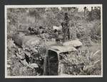 Four men looking at postwar debris, Rabaul, Sep 1949