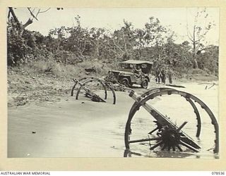 BOUGAINVILLE ISLAND, 1945-01-20. A JEEP OF "A" COMPANY, 42ND INFANTRY BATTALION NEGOTIATING THE BEACH ROAD BETWEEN MAWARAKA VILLAGE AND THE JABA RIVER. NOTE THE WRECKAGE OF THE JAPANESE ARTILLERY ..