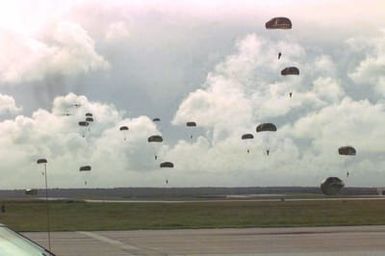 Several US Marines from 2nd Platoon, Company A, 5th Reconnaissance Battalion, 3rd Marine Division, glide down to terra firma with the MC1-1 parachute over the drop zone after they jumped from a US Air Force C-141 Starlifter (in background) 800 feet above sea level during the Force Reconnaissance Exercises