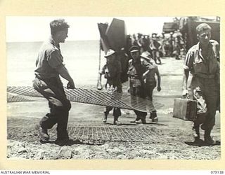 TSIMBA AREA, BOUGAINVILLE ISLAND. 1945-02-16. TROOPS OF THE 4TH FIELD REGIMENT, LAYING WIRE MESH ON THE BEACH IN PREPARATION FOR THE LANDING OF THEIR JEEPS AND TRUCKS ON THE SOFT SAND AT PUTO