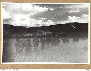 RAMU VALLEY, NEW GUINEA, 1943-10-01. MEN OF THE 2/27TH AUSTRALIAN INFANTRY BATTALION CROSSING THE VALLEY FLOOR IN THE LATE AFTERNOON