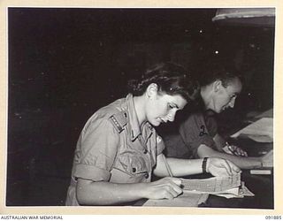 LAE, NEW GUINEA, 1945-05-16. SIGNALWOMAN D. AVERY (1), AND CORPORAL K.W. GREENWOOD (2), CHECK CLERKS AT THE SIGNALS OFFICE, HEADQUARTERS FIRST ARMY. AUSTRALIAN WOMEN'S ARMY SERVICE PERSONNEL ARE ..