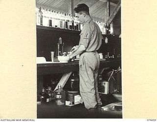 LAE, NEW GUINEA. 1944-07-14. VX120553 STAFF SERGEANT R.A. FAIRLEY (1) MAKING UP A PRESCRIPTION IN THE DISPENSARY OF THE 2/7TH AUSTRALIAN GENERAL HOSPITAL