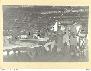 THE SEVENTEEN MILE, PORT MORESBY, NEW GUINEA. 1943-07-03. INSIDE THE PHYSIOTHERAPY SECTION OF THE 2/9TH AUSTRALIAN GENERAL HOSPITAL. LEFT TO RIGHT:- UNIDENTIFIED, VX90308 LIEUTENANT D.E. COOPER, ..