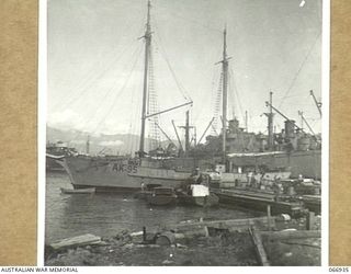 LAE, NEW GUINEA. 1944-06-14/02. THE AK95 A VESSEL OF THE 12TH WATER TRANSPORT OPERATING COMPANY, WITH UNITED STATES LIBERTY SHIPS MOORED IN THE BACKGROUND