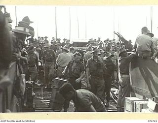 SOUTH ALEXISHAFEN, NEW GUINEA. 1944. AUSTRALIAN TROOPS UNLOADING THE COURIER BARGE OF THE 593RD UNITED STATES BARGE COMPANY FOR THE RETURN TRIP TO MADANG