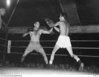 Private (Pte) Sam Moy, (United States of America) (left) and Pte Sully (Australia) (right), spar for an opening during a boxing tournament between Australian and American servicemen. The Australian ..