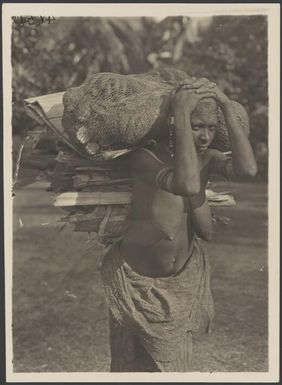 Woman carrying garden produce, Eroro village, Oro Bay, Papua New Guinea, ca. 1922 / Frank Hurley