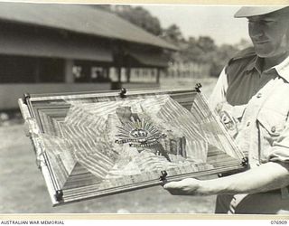 LAE AREA, NEW GUINEA. 1944-11-17. NP2182 WARRANT OFFICER II, J.R. DEN, A MEMBER OF THE PERMANENT MILITARY FORCES, AND A CABINET MAKER BY TRADE, PRODUCED THIS BEAUTIFUL TRAY FROM PERSPEX, BATTERY ..