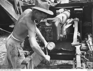 BOUGAINVILLE, SOLOMON ISLANDS. 1944-12-10. LANCE SERGEANT N.A. BUTTON, D TROOP, 5 BATTERY, 2 FIELD REGIMENT, ROYAL AUSTRALIAN ARMY, FITS A PRESSURE GAUGE MEASURING THE TOOTING PRESSURE OF THE ..