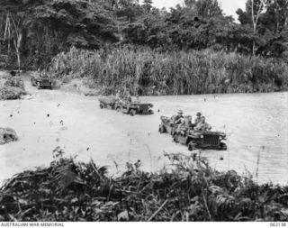 SONG RIVER, NEW GUINEA. 1943-12-21. TRANSPORT OF THE 1ST AUSTRALIAN TANK BATTALION GROUP WORKSHOP, AUSTRALIAN ELECTRICAL AND MECHANICAL ENGINEERS, CROSSING THE RIVER NEAR FINSCHHAFEN ON THE MAIN ..