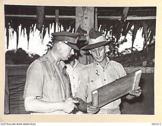 LAE AREA, NEW GUINEA, 1945-06-28. HIS ROYAL HIGHNESS, THE DUKE OF GLOUCESTER, GOVERNOR-GENERAL OF AUSTRALIA (1) VISITING 112 CONVALESCENT DEPOT, EXAMINES A TRAY MADE BY ONE OF THE HOBBYISTS AT THE ..