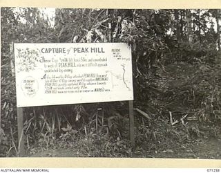 FINSCHHAFEN AREA, NEW GUINEA, 1944-03-18. ONE OF MANY BATTLE SIGNS IN THE FINSCHHAFEN AREA, THIS SIGN RECORDS ACTIVITIES OF THE 2/24TH INFANTRY BATTALION, 26TH INFANTRY BRIGADE CAPTURING PEAK HILL, ..