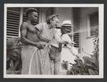 Man watering garden while a woman and man watch, Hotel Papua, Port Moresby, c1950