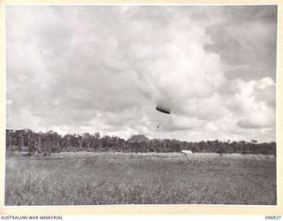 KAHILI, BOUGAINVILLE. 1945-09-10. SUPPLIES BEING PARACHUTED ON KAHILI AIRSTRIP FOR THE BUIN LIAISON PARTY FROM HEADQUARTERS 2 CORPS. THE BUIN LIAISON PARTY IS ORGANISING SURRENDER DETAILS IN THE ..