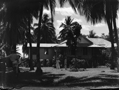 [People in front of buildings in Pacific Island location]