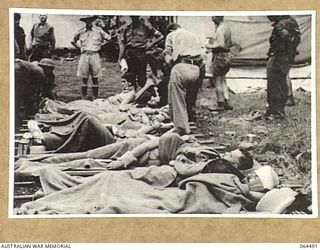 MELBOURNE, VICTORIA, AUSTRALIA. 1944-03-03. COPY OF A SCENE FROM A CINE STRIP OF AUSTRALIAN WOUNDED BEING CHECKED IN AT A FIELD DRESSING STATION SOMEWHERE IN NEW GUINEA