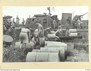 MADANG, NEW GUINEA, 1944-04-30. AUSTRALIAN TROOPS LOAD HIGH OCTANE AVIATION SPIRIT ABANDONED BY THE JAPANESE IN DUMPS AT MADANG AIRFIELD. THE PETROL WAS FOUND SUITABLE FOR THE MOTORS IN HMA MOTOR ..