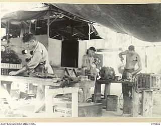 ALEXISHAFEN, NEW GUINEA. 1944-09-13. NX13140 SERGEANT P. RAPPO (1) NX157082 CRAFTSMAN J. MILLER (2) AND QX51658 CRAFTSMAN G.B. WILSON (3) WORKING IN THE ELECTRICAL SECTION OF THE 133RD BRIGADE ..