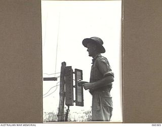 SOGERI, NEW GUINEA. 1943-11-20. VX138217 SIGNALMAN R. J. H. PUGSLEY, 6TH AUSTRALIAN INFANTRY BRIGADE SIGNALS SECTION, A STUDENT AT AT THE SCHOOL OF SIGNALS, NEW GUINEA FORCE WIRING A TERMINAL BOX ..