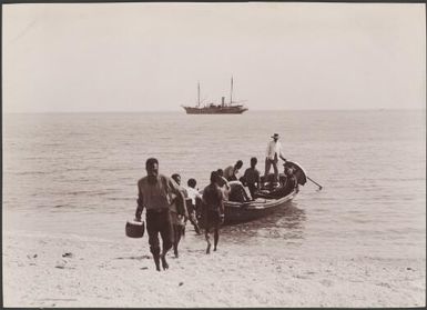 Men unloading teachers pay from boat at Lotora, Southern Cross in background, New Hebrides, 1906 / J.W. Beattie