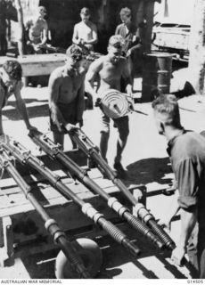 1943-03-29. NEW GUINEA. ARMOURERS OF A RAAF BEAUFIGHTER SQUADRON AT AN ADVANCED BASE IN NEW GUINEA OVERHAULING CANNON FROM THE MACHINES. THOUSANDS OF SHELLS FROM CANNON SUCH AS THESE WERE FIRED ..
